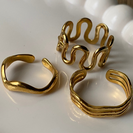 Three gold rings on a white surface